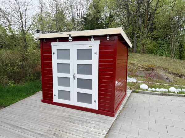 Rødmalt bod på heller med dører igjen og små ruter i døren. Info i bildet på størrelse og fordeler. Kundebilde