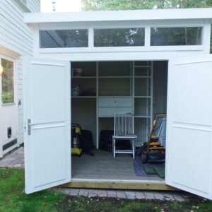 Hvitmalt bod i mijø med doble dører og vindu på topp. Dører åpne. Kundebilde