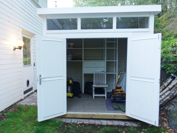 Hvitmalt bod i mijø med doble dører og vindu på topp. Dører åpne. Kundebilde