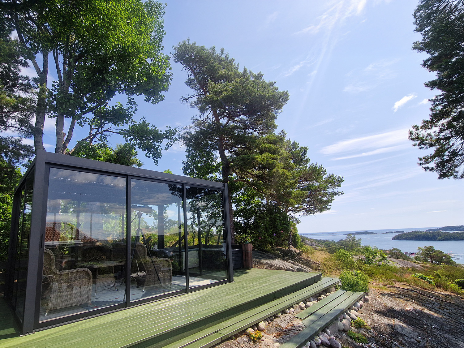 Pergola med glassvegger på hytte i Stathelle – en lun uteplass med spektakulær utsikt